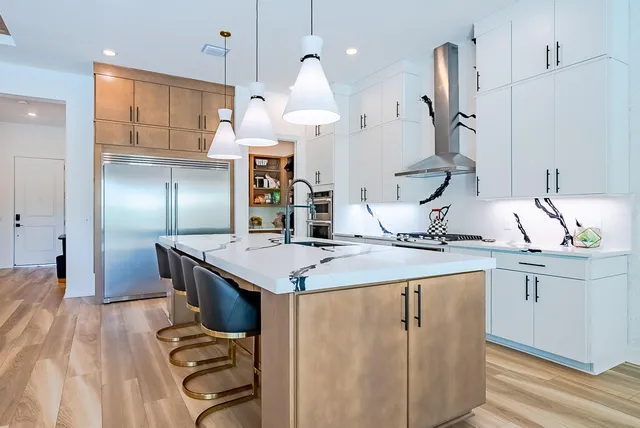 a kitchen with stainless steel appliances granite countertop a sink a stove and a refrigerator