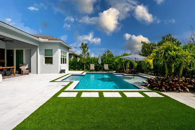 a view of a swimming pool with a patio and a yard