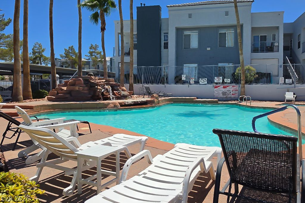 2201 Ramsgate Drive, Unit 514 Henderson, NV 89074 - Photo 24 of 28 A refreshing pool area featuring a rock waterfall and ample lounging space.