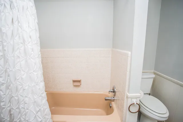 a view of a backyard with a tree and wooden fence