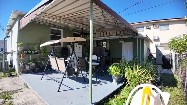 a view of a porch with dining table and chairs
