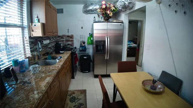 a kitchen with stainless steel appliances granite countertop a sink refrigerator and microwave