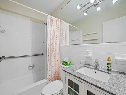 a bathroom with a granite countertop sink toilet and shower