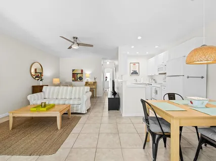 a living room with a table chairs and a kitchen view