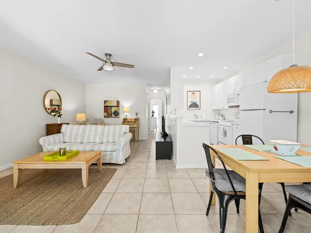 a living room with a table chairs and a kitchen view