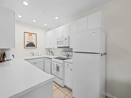 a kitchen with cabinets a sink and white stainless steel appliances