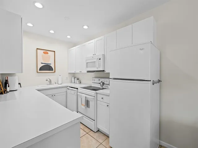 a kitchen with cabinets a sink and white stainless steel appliances