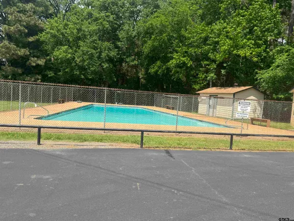 a view of pool with small trees
