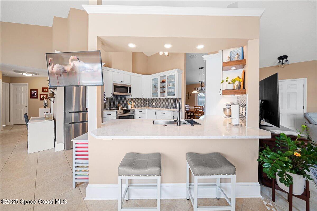 171 Seaview Street Melbourne Beach, FL 32951 - Photo 12 of 44 a living room with stainless steel appliances kitchen island granite countertop furniture and a view of kitchen