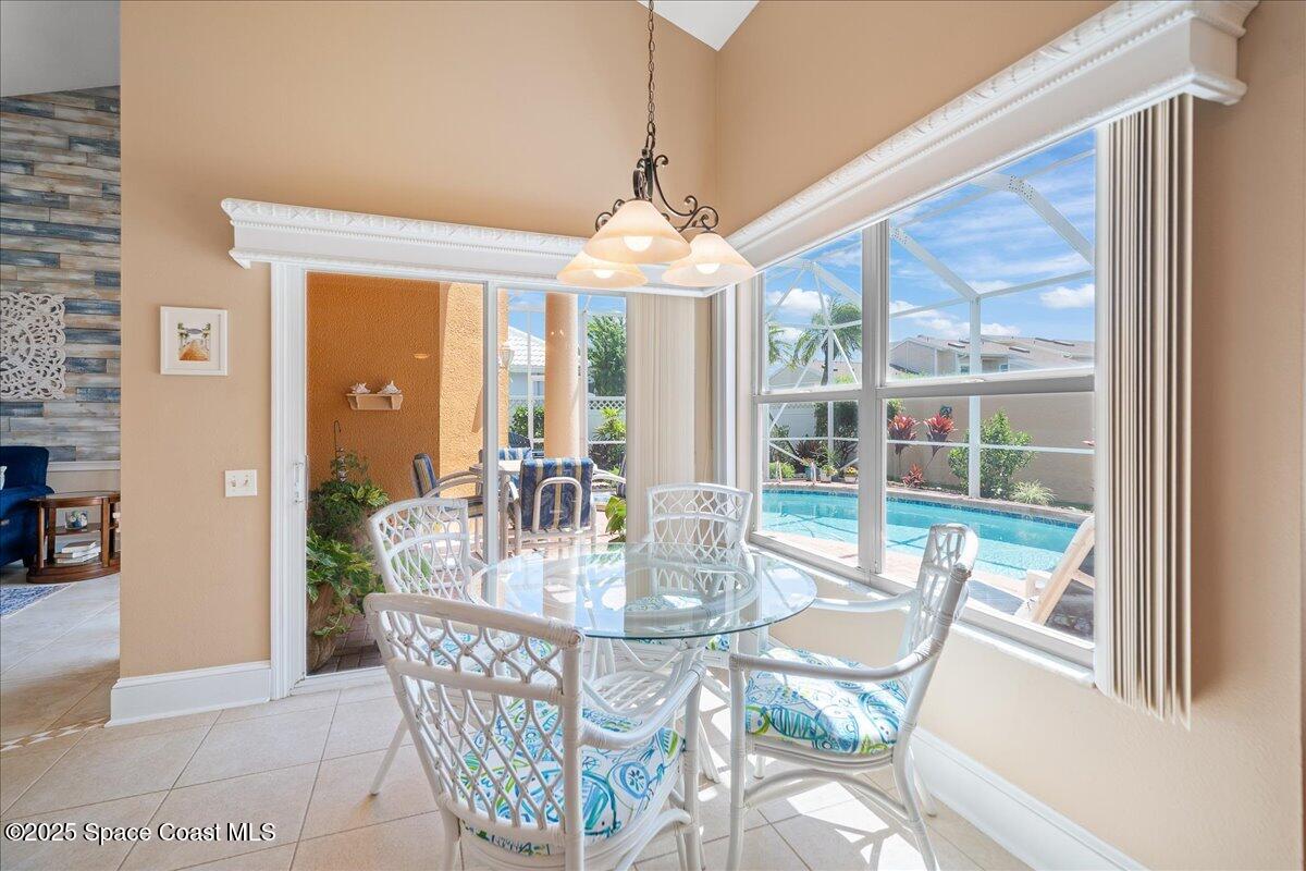 171 Seaview Street Melbourne Beach, FL 32951 - Photo 15 of 44 a dining room with furniture a chandelier and wooden floor