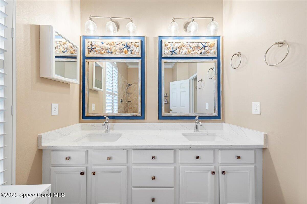 171 Seaview Street Melbourne Beach, FL 32951 - Photo 19 of 44 a bathroom with double vanity and a mirror