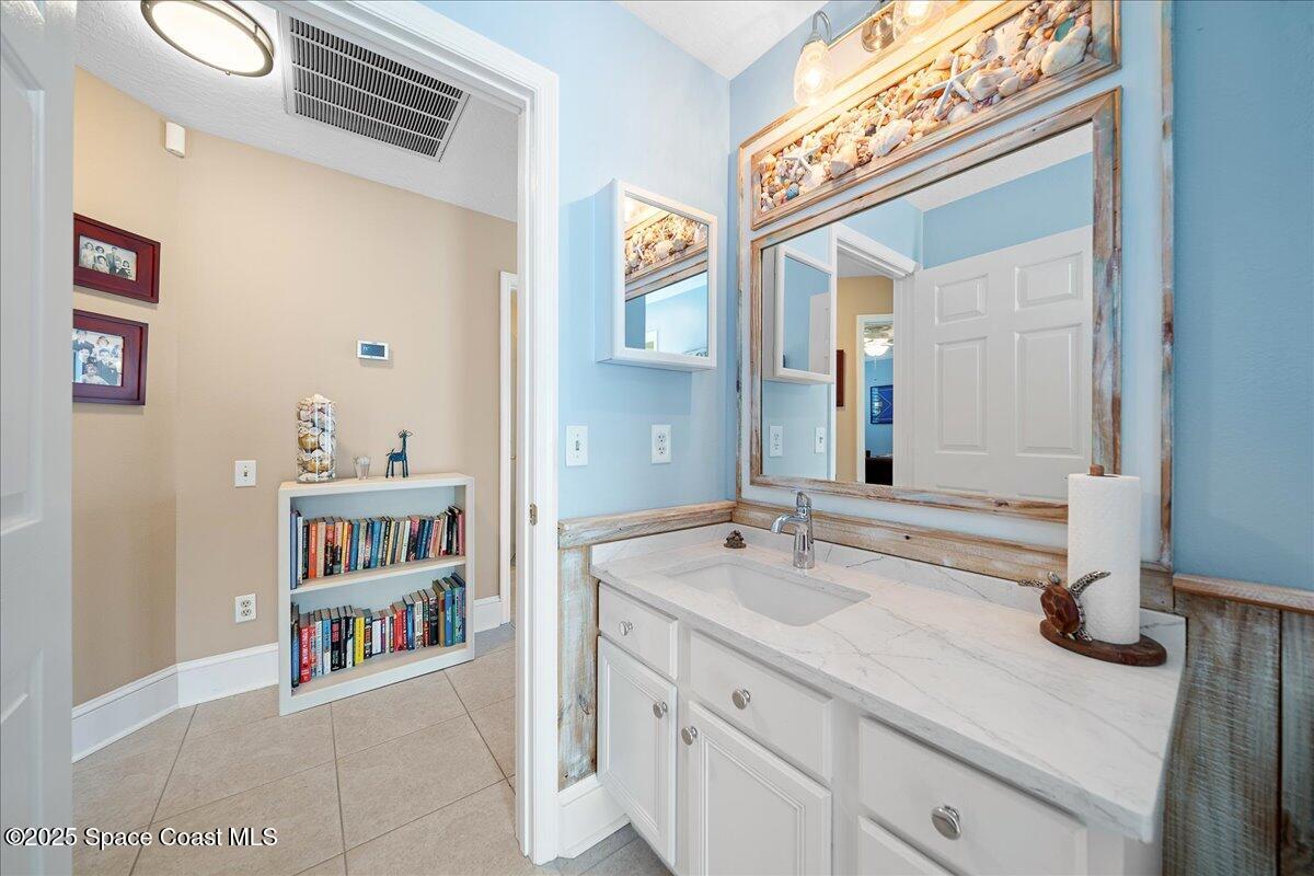 171 Seaview Street Melbourne Beach, FL 32951 - Photo 25 of 44 a en suite bathroom with a sink double vanity and a mirror
