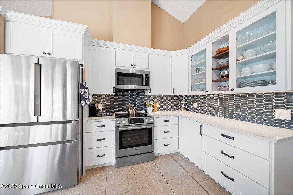 171 Seaview Street Melbourne Beach, FL 32951 - Photo 10 of 44 a kitchen with stainless steel appliances a refrigerator sink and cabinets