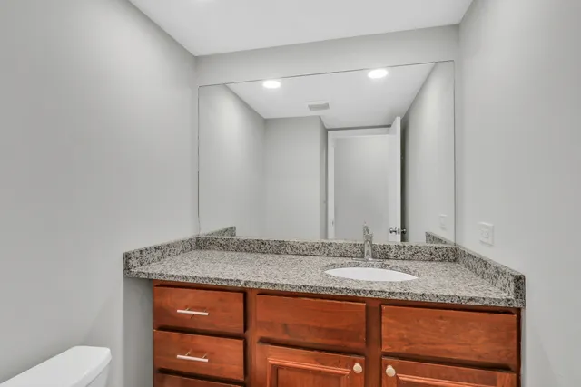 a bathroom with a granite countertop sink and a mirror