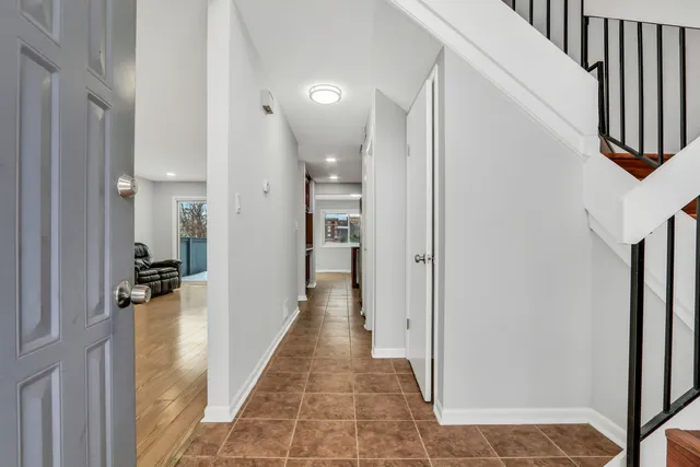 a view of a hallway with white walls and stairs