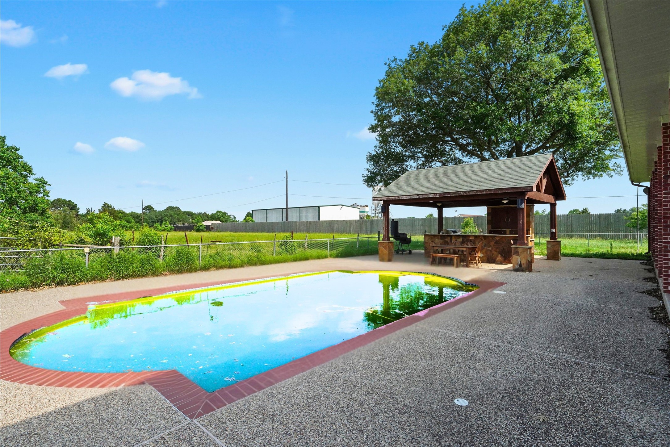 19250 Becker Road Hockley, TX 77447 - Photo 12 of 38 Cool off in the sparkling pool and unwind under the shade of the covered outdoor kitchen, perfect for summer weekends.