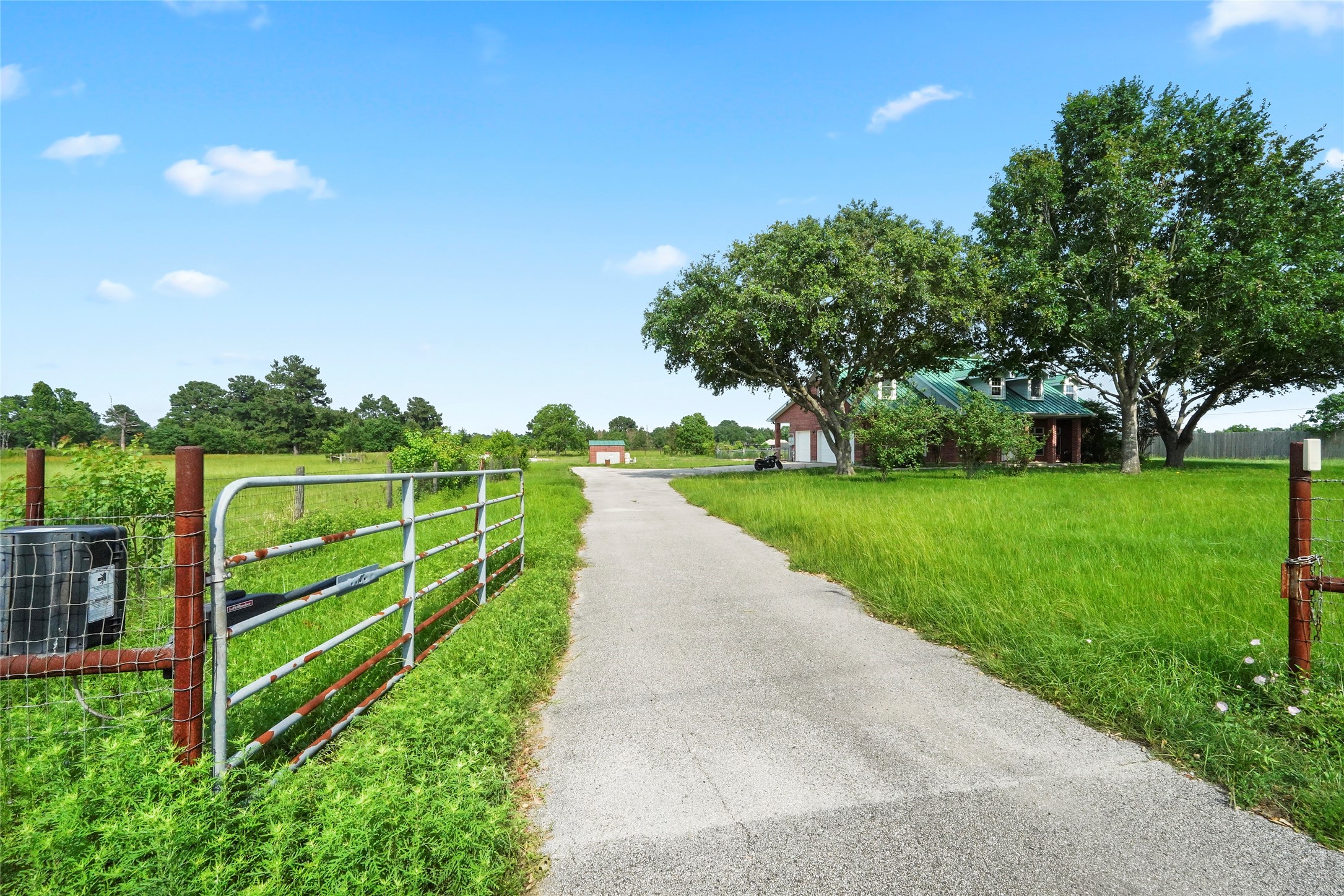 19250 Becker Road Hockley, TX 77447 - Photo 14 of 38 Gated entry opens to a long private drive with mature trees and open pasture views leading up to the home.