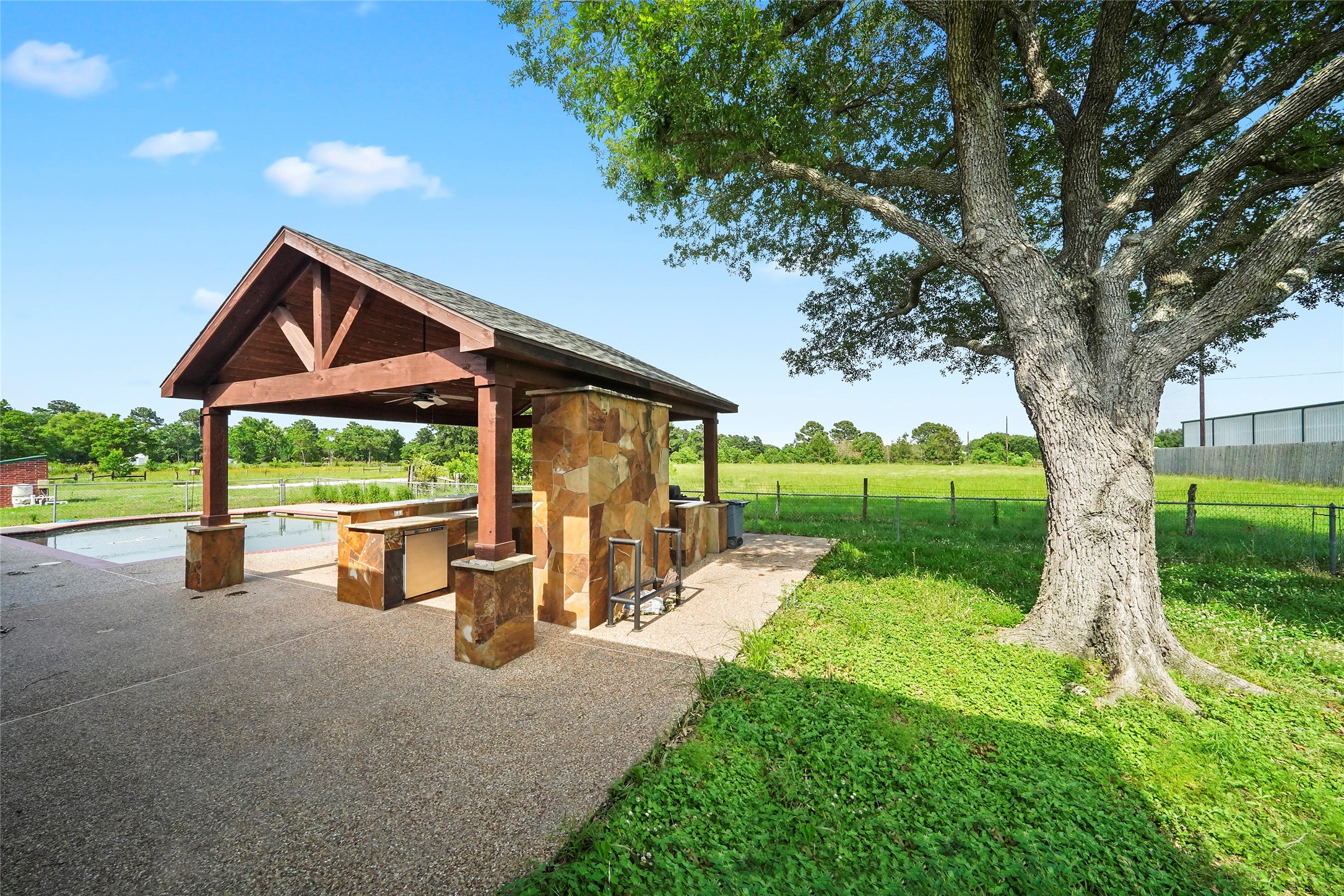 19250 Becker Road Hockley, TX 77447 - Photo 9 of 38 Surrounded by mature trees and fencing, this backyard oasis blends rustic charm with thoughtful amenities.
