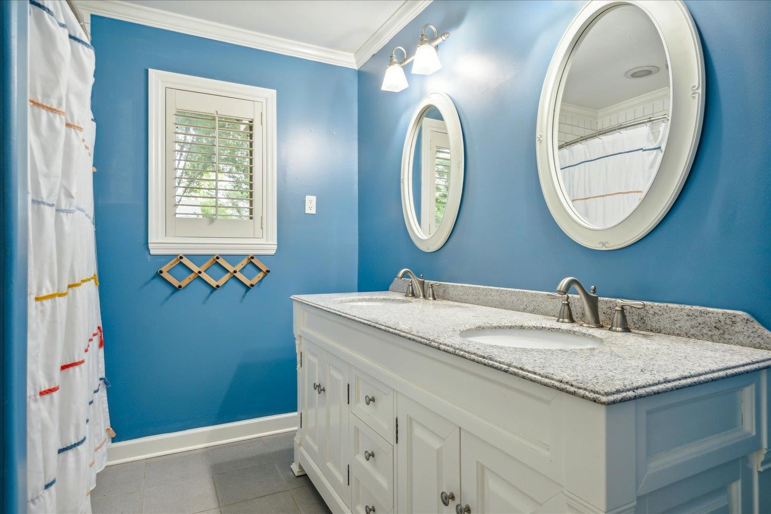 5517 Normandy Road Memphis, TN 38120 - Photo 20 of 24 a bathroom with a granite countertop sink and a mirror