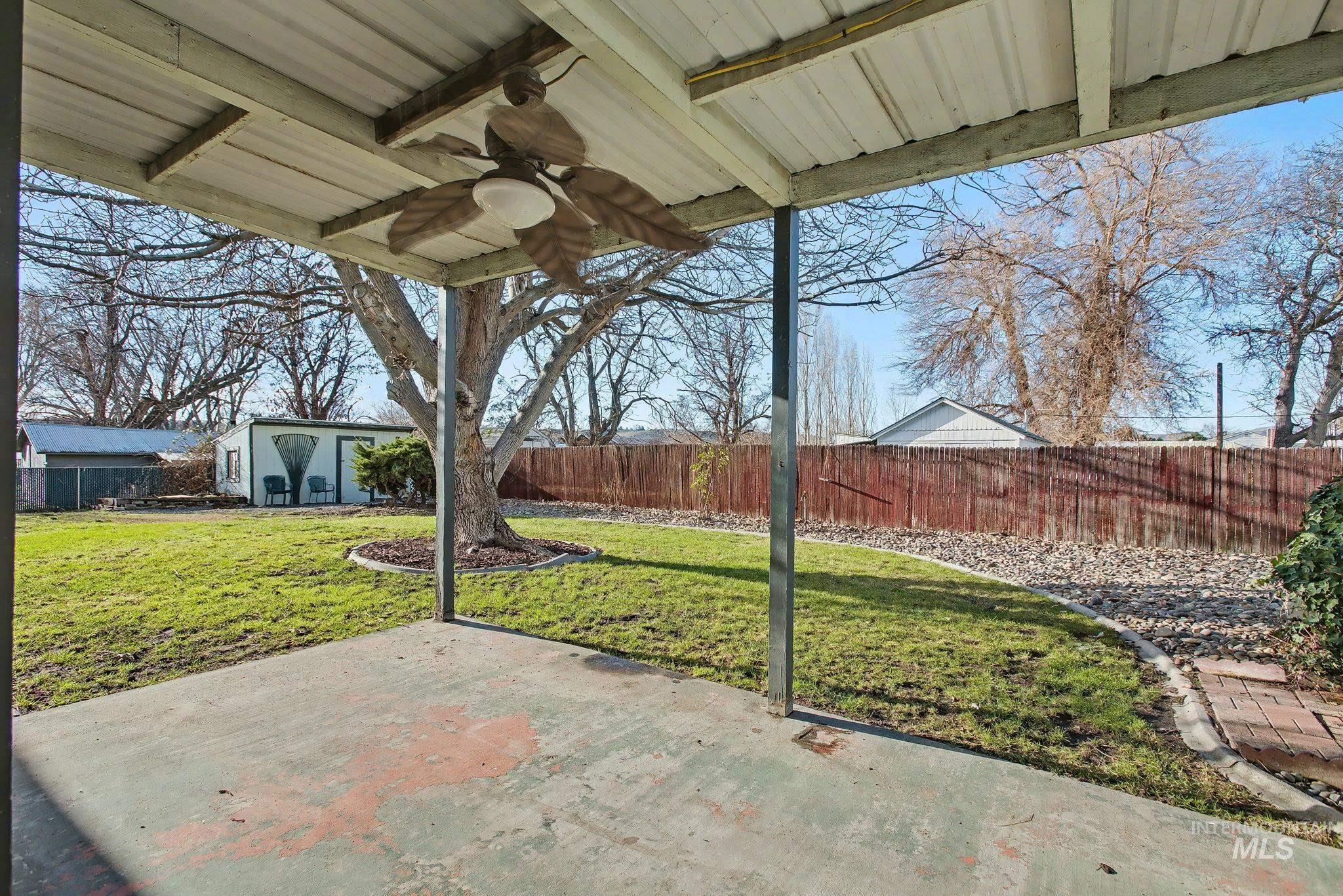 408 13th Street Clarkston, WA 99403 - Photo 29 of 34 Fenced backyard featuring a ceiling fan, an outbuilding, and a patio area