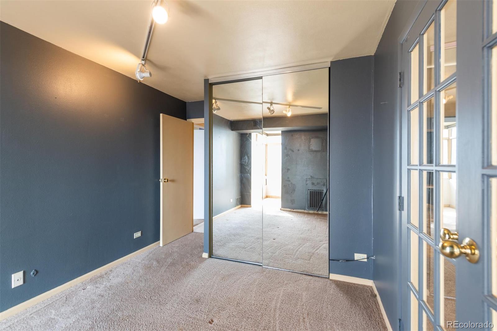 1313 North Williams Street, Unit 906 Denver, CO 80218 - Photo 16 of 31 a bedroom with a bed and a chandelier