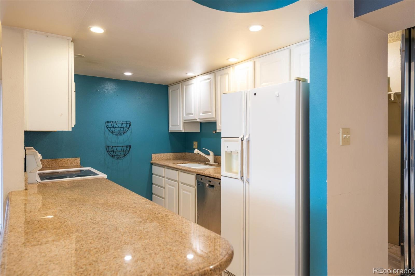 1313 North Williams Street, Unit 906 Denver, CO 80218 - Photo 7 of 31 a kitchen with stainless steel appliances a refrigerator and a stove