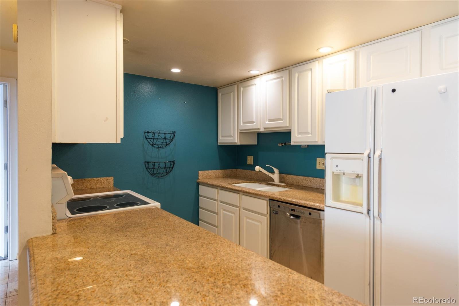 1313 North Williams Street, Unit 906 Denver, CO 80218 - Photo 9 of 31 a kitchen with a refrigerator sink and cabinets