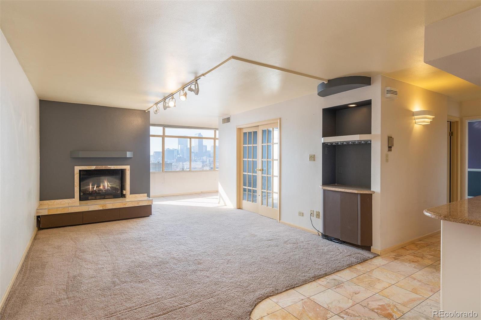 1313 North Williams Street, Unit 906 Denver, CO 80218 - Photo 10 of 31 a view of an empty room with a fireplace and a window