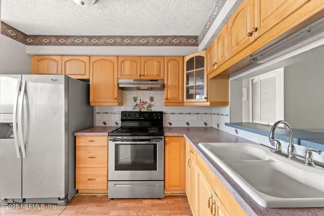 a kitchen with stainless steel appliances a stove a refrigerator and a sink