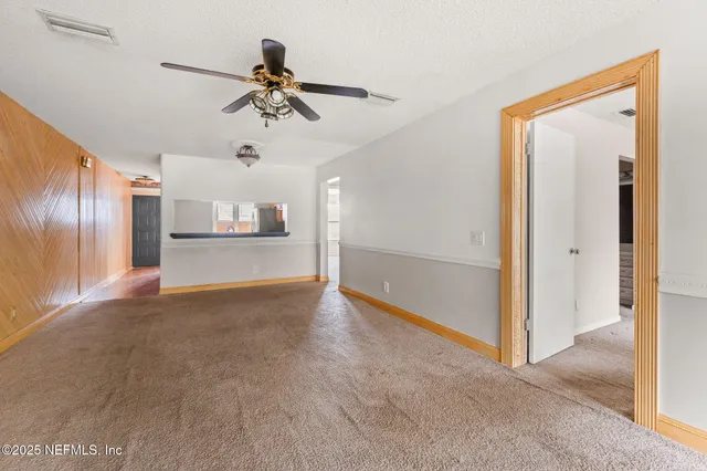 a view of empty room with cabinet and floor to ceiling window