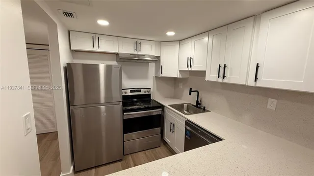 a kitchen with refrigerator cabinets and a sink