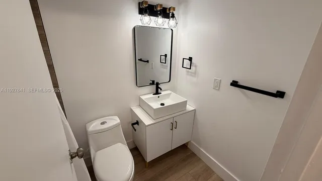 a bathroom with a sink toilet and mirror