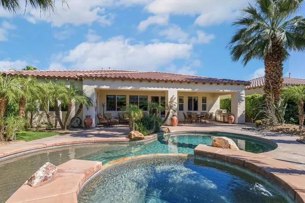 a view of a house with backyard swimming pool and sitting area