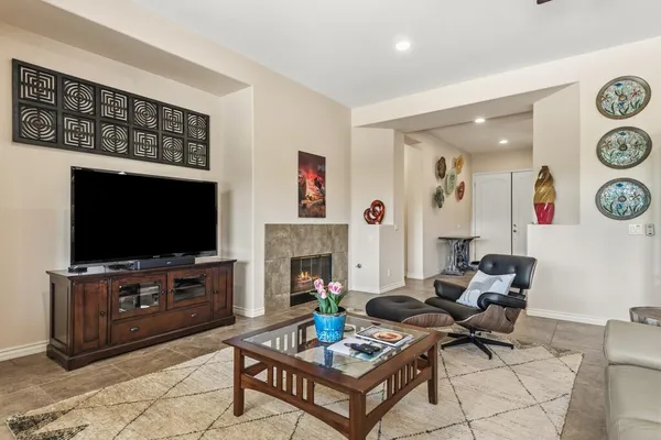 a living room with furniture a flat screen tv and a fireplace