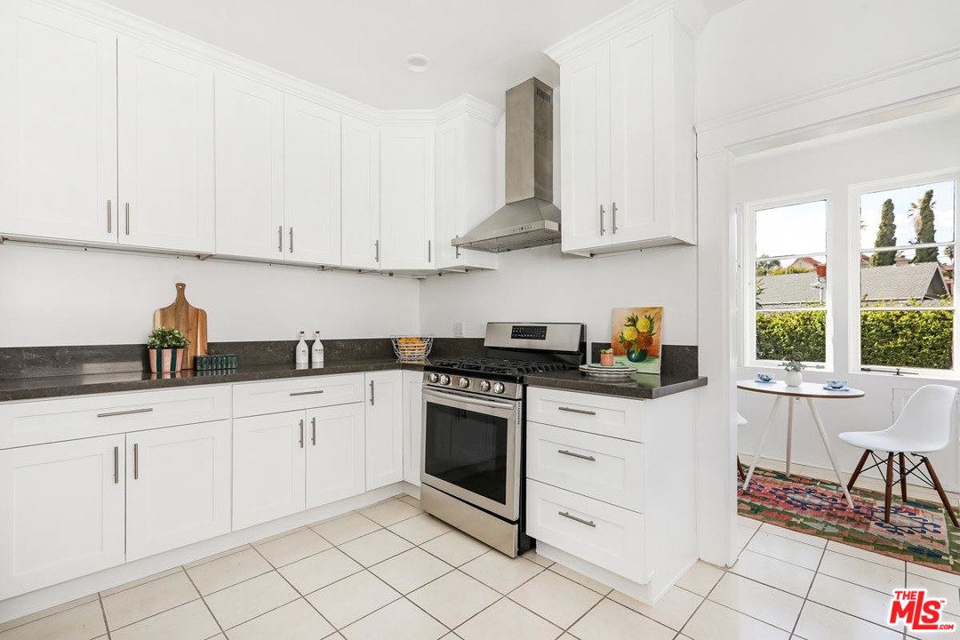 755 East Kensington Road Los Angeles, CA 90026 - Photo 11 of 25 a kitchen with white cabinets and white appliances