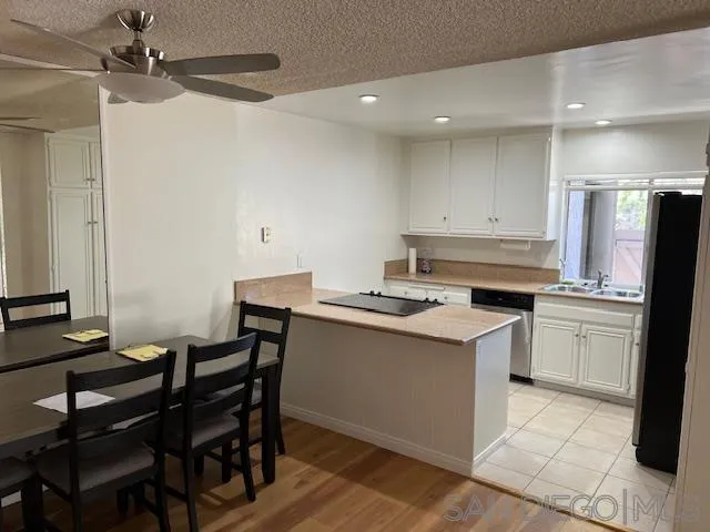 9564 Easter Way San Diego, CA 92121 - Photo 3 of 16 a kitchen with a stove a refrigerator and a dining table
