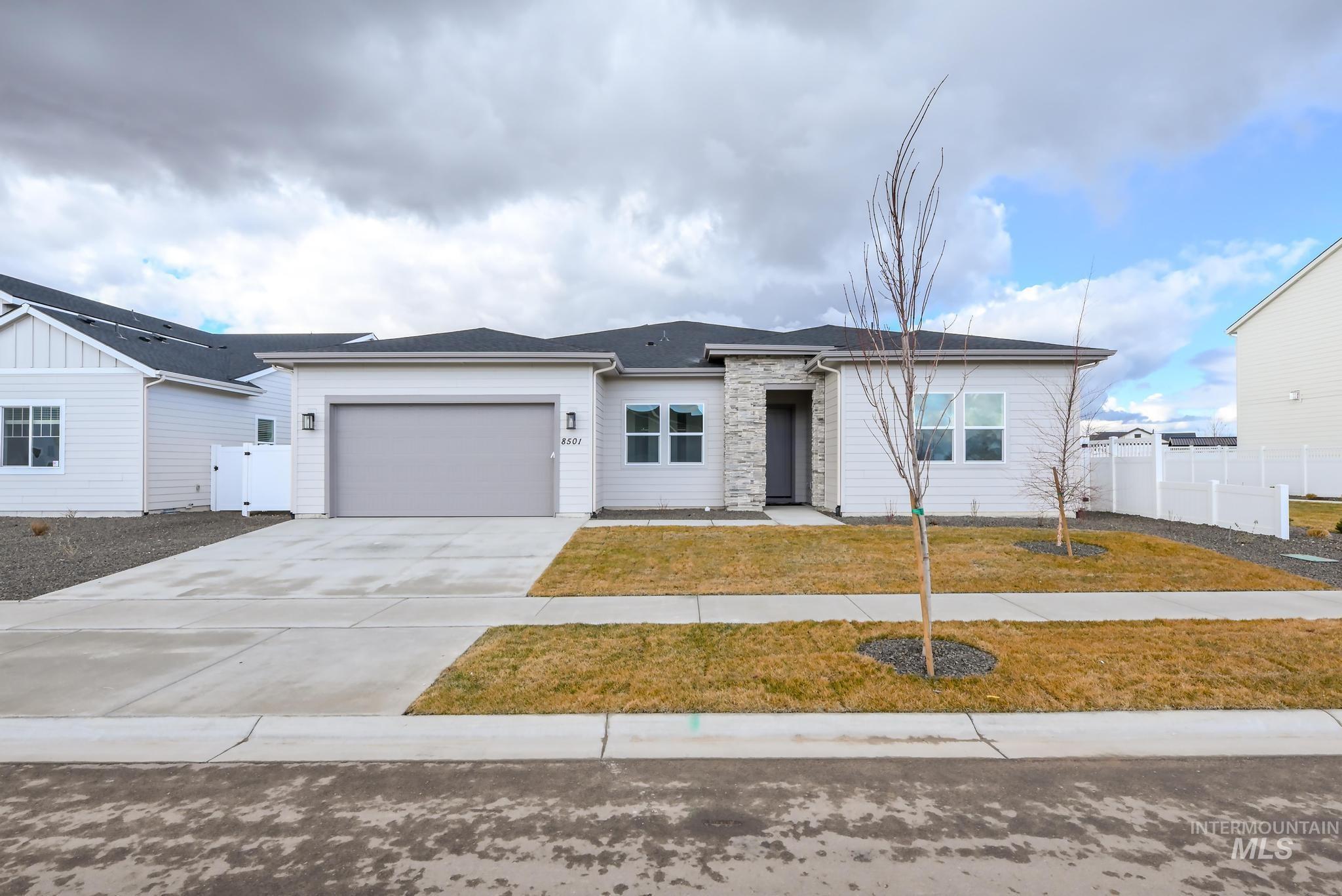 Ranch-style house featuring concrete driveway, a garage, and a gate