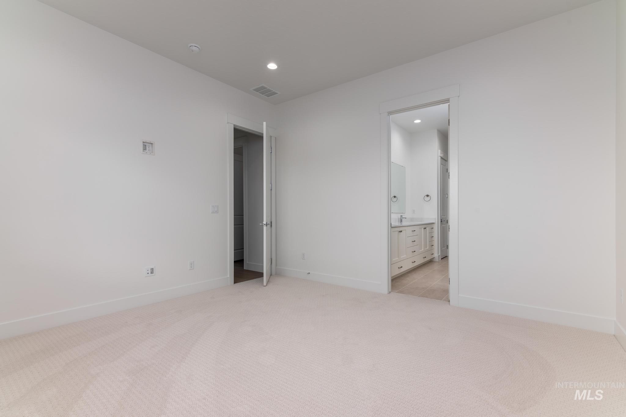 8501 South Country Wind Avenue Meridian, ID 83642 - Photo 17 of 38 Unfurnished bedroom featuring light carpet, recessed lighting, and connected bathroom