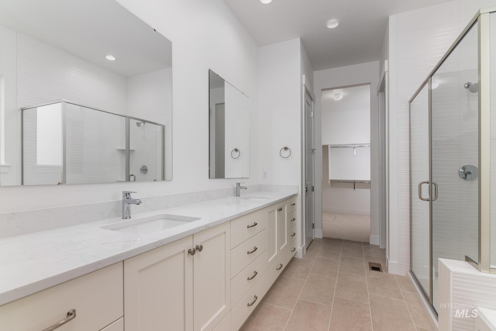 8501 South Country Wind Avenue Meridian, ID 83642 - Photo 18 of 38 Bathroom featuring a shower stall, double vanity, light tile patterned floors, a walk in closet, and recessed lighting