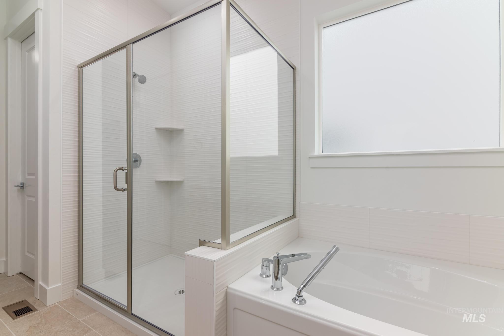 8501 South Country Wind Avenue Meridian, ID 83642 - Photo 19 of 38 Bathroom with a stall shower, a bath, and light tile patterned floors