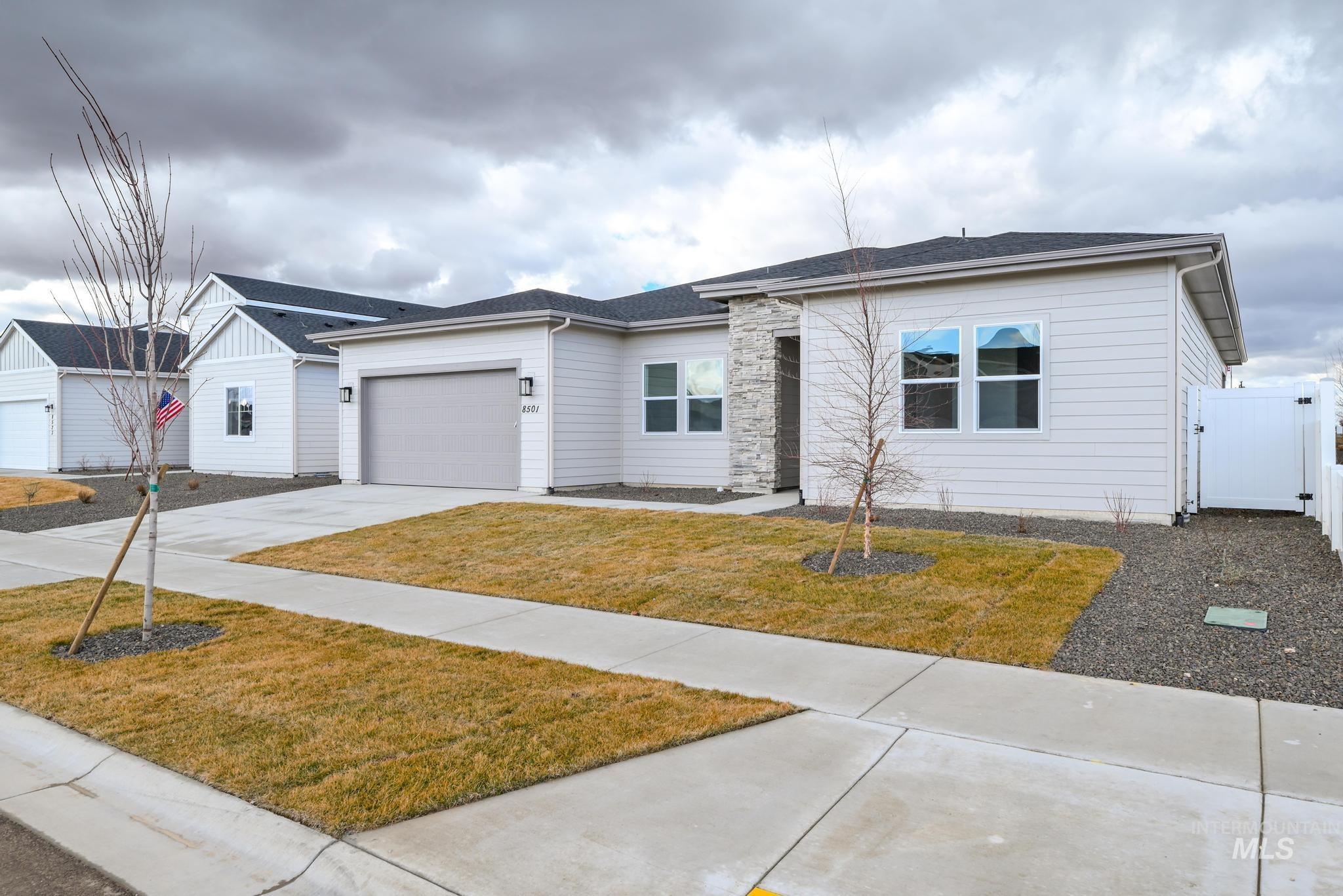 8501 South Country Wind Avenue Meridian, ID 83642 - Photo 3 of 38 Single story home with concrete driveway, a gate, an attached garage, a shingled roof, and a front yard