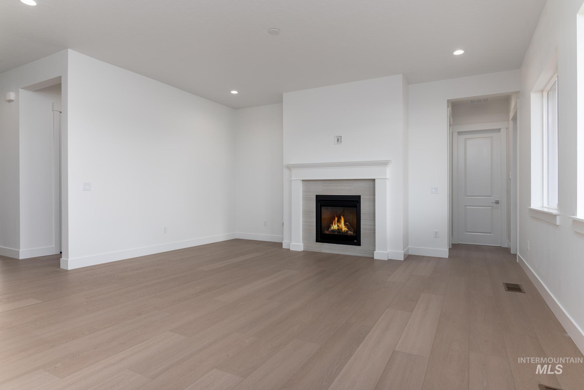 8501 South Country Wind Avenue Meridian, ID 83642 - Photo 4 of 38 Unfurnished living room with a fireplace, recessed lighting, and light wood-type flooring