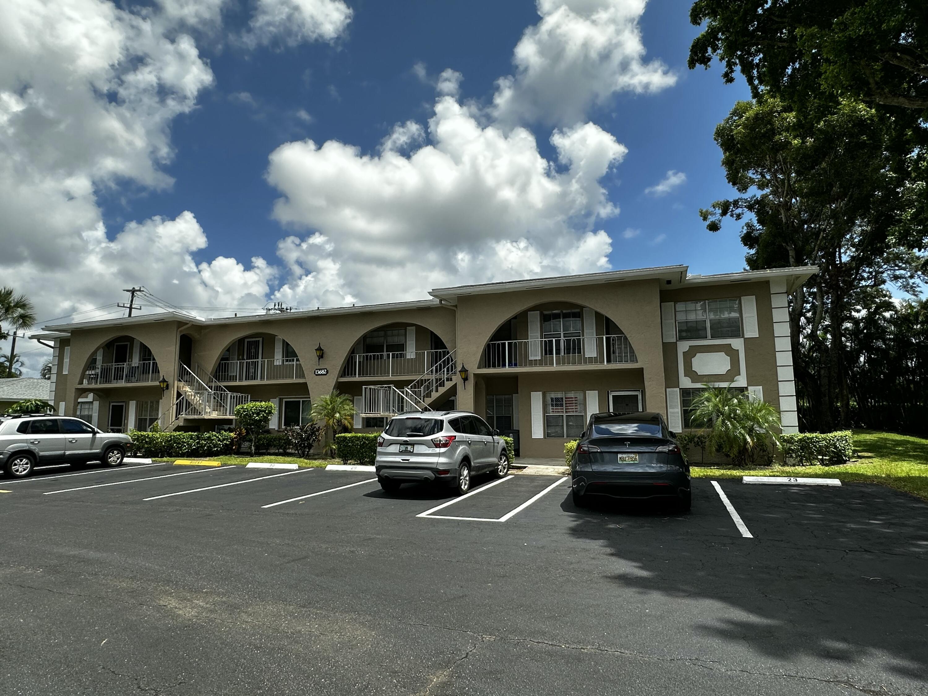 13682 Vía Flora, Unit H Delray Beach, FL 33484 - Photo 1 of 28 a couple of cars parked in front of a house