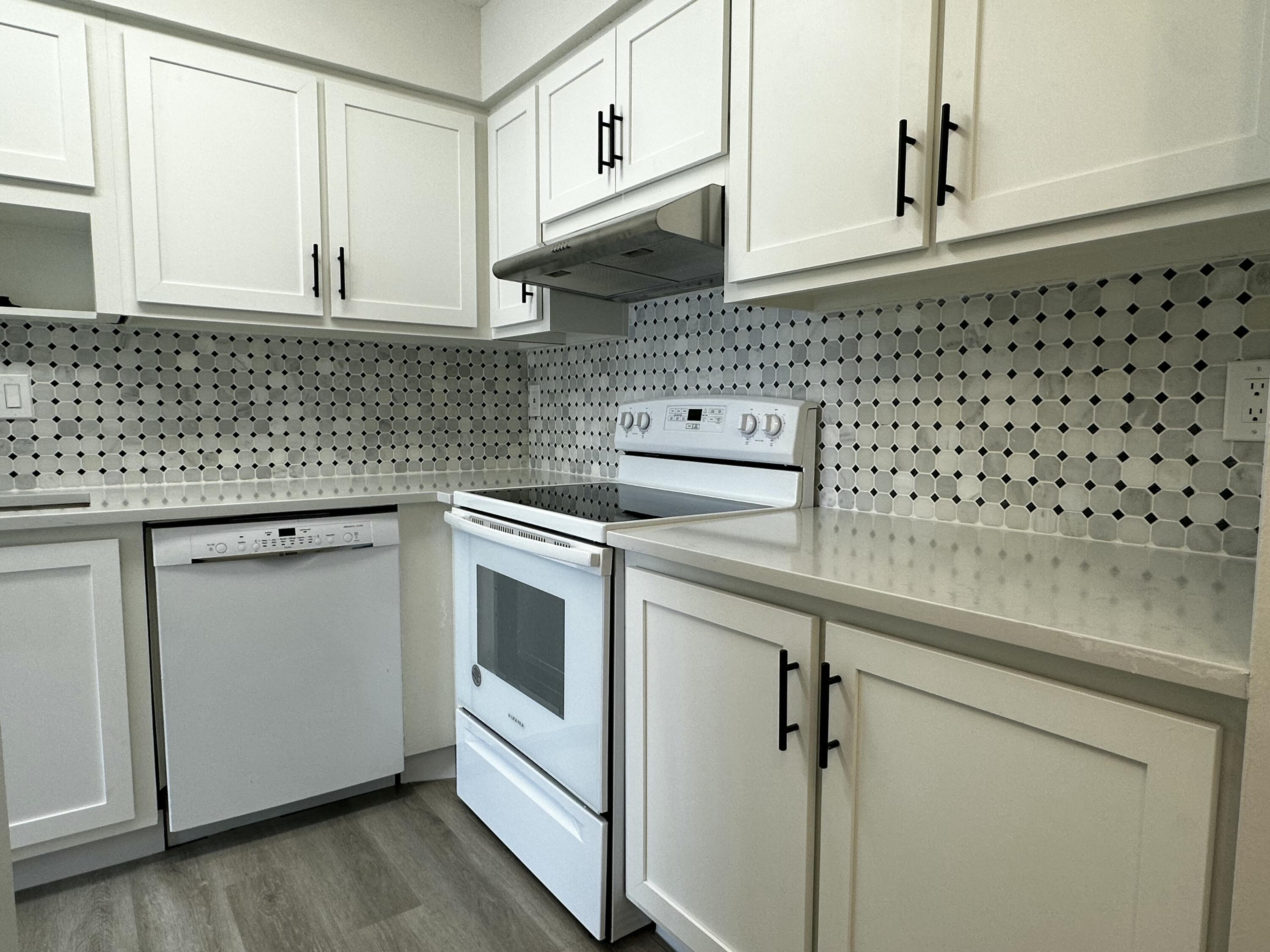 13682 Vía Flora, Unit H Delray Beach, FL 33484 - Photo 12 of 28 a kitchen with granite countertop white cabinets and white appliances