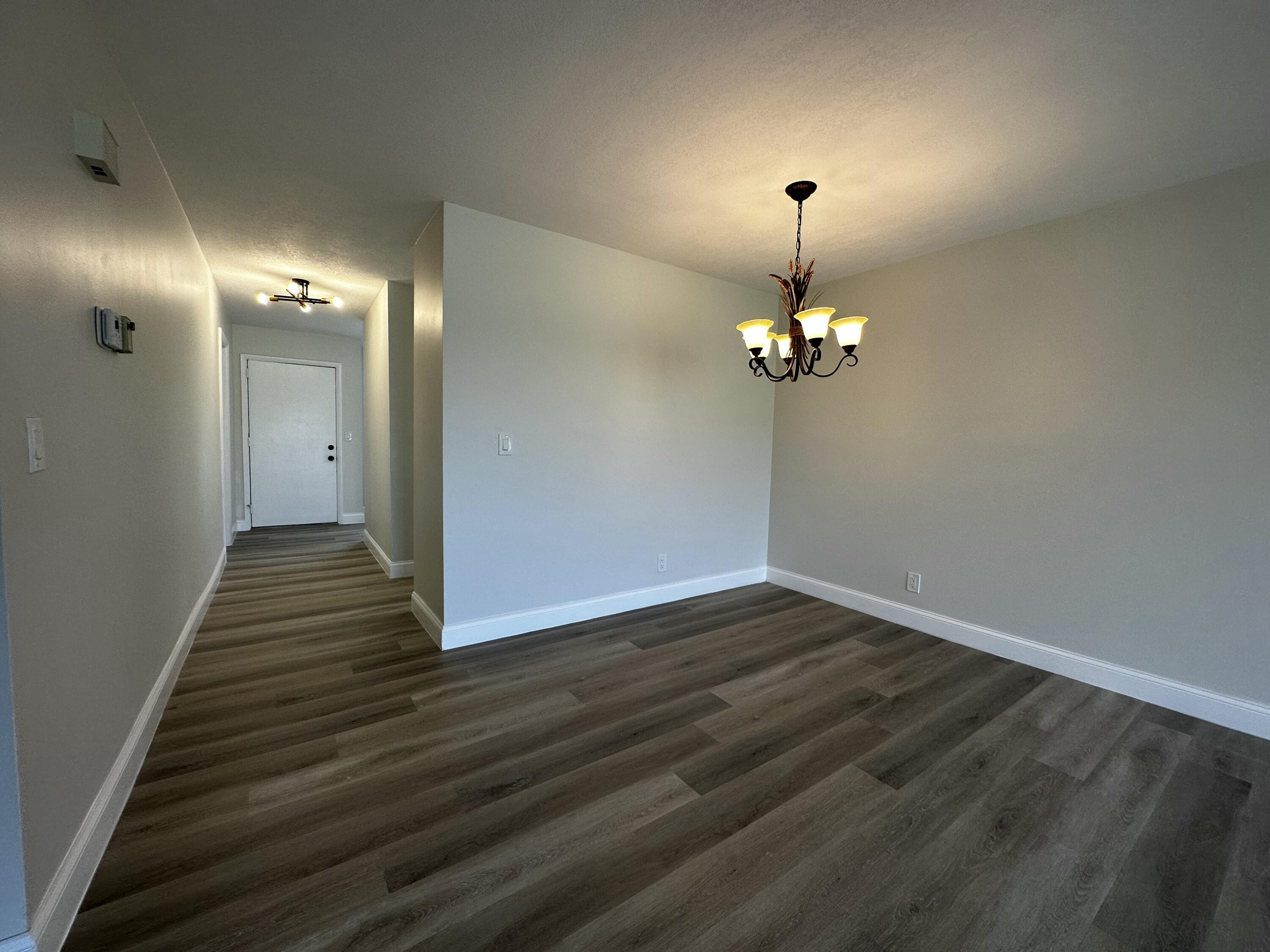 13682 Vía Flora, Unit H Delray Beach, FL 33484 - Photo 14 of 28 a view of a livingroom with wooden floor a chandelier