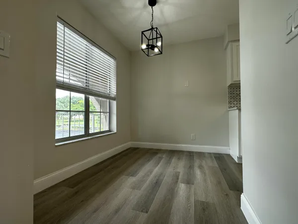 a view of a room with wooden floor and a window
