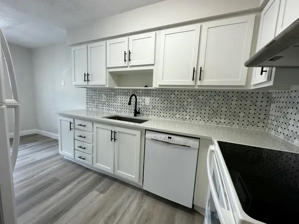 a kitchen with stainless steel appliances granite countertop a sink stove and cabinets