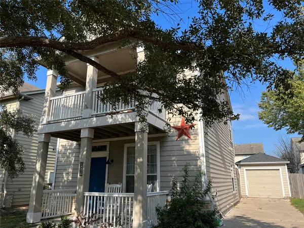 a front view of a house with a tree
