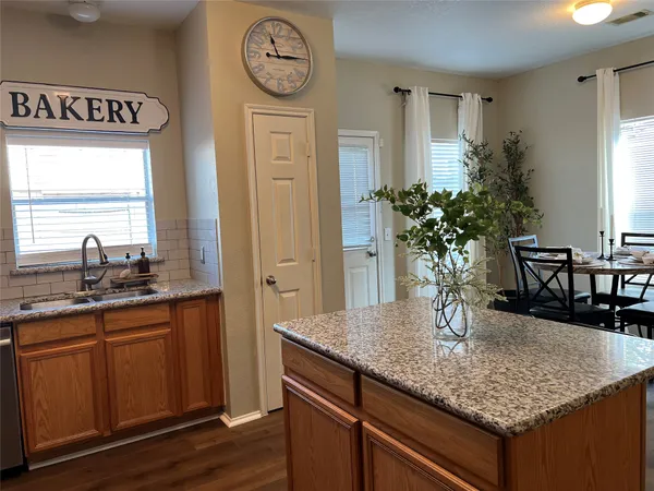 a kitchen with a table chairs and wooden floor