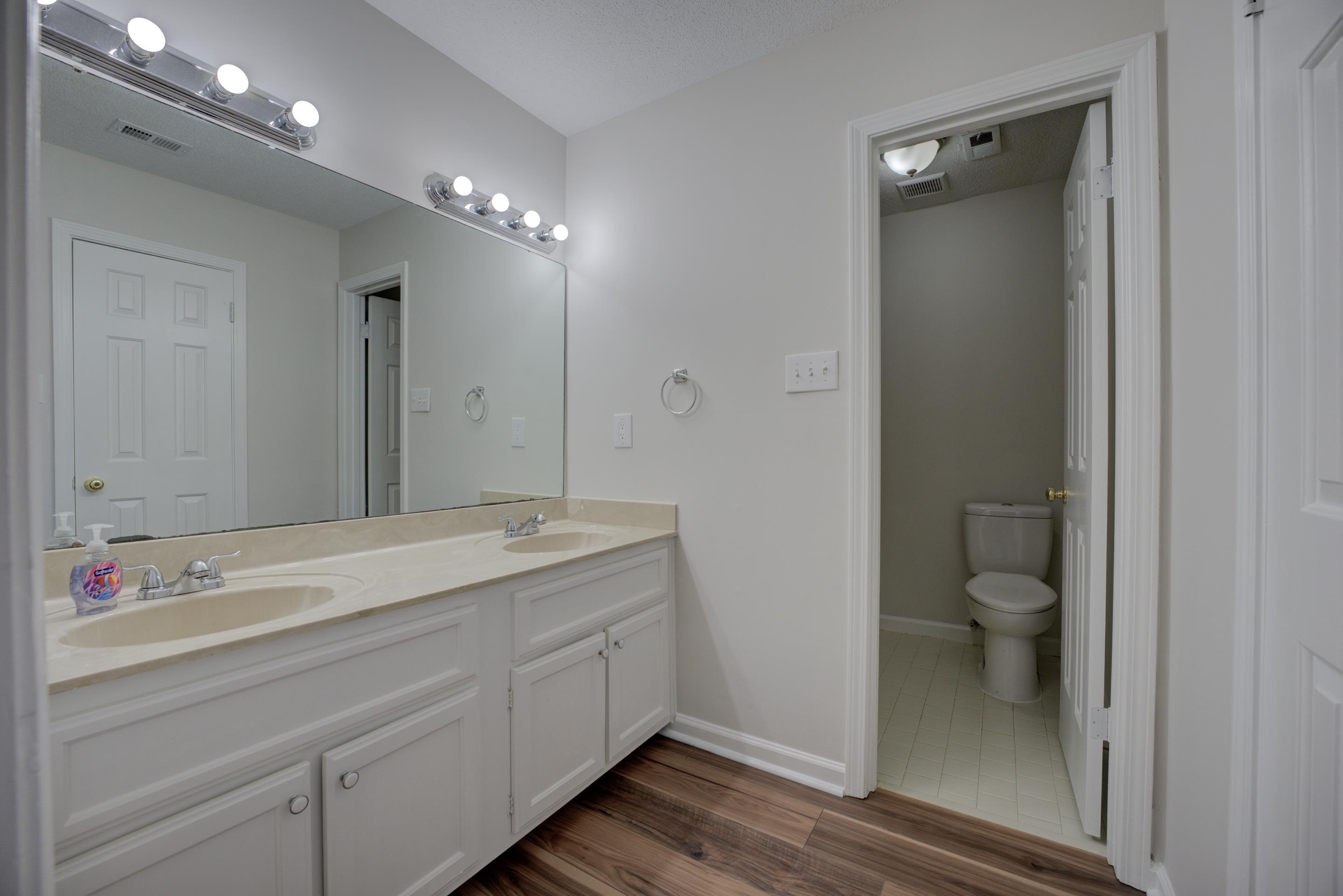 7555 Reese Road Memphis, TN 38133 - Photo 12 of 22 Bathroom featuring toilet, vanity, and hardwood / wood-style flooring